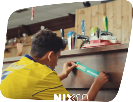 Jongetje plakt NIX18 sticker op de bar van de sportkantine
